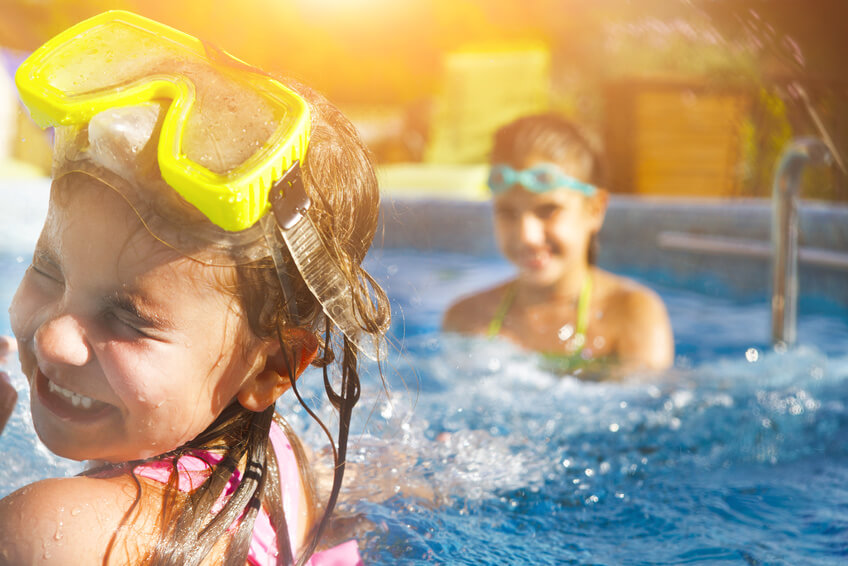 Children playing in pool. Two little girls having fun in the pool. Summer holidays and vacation concept