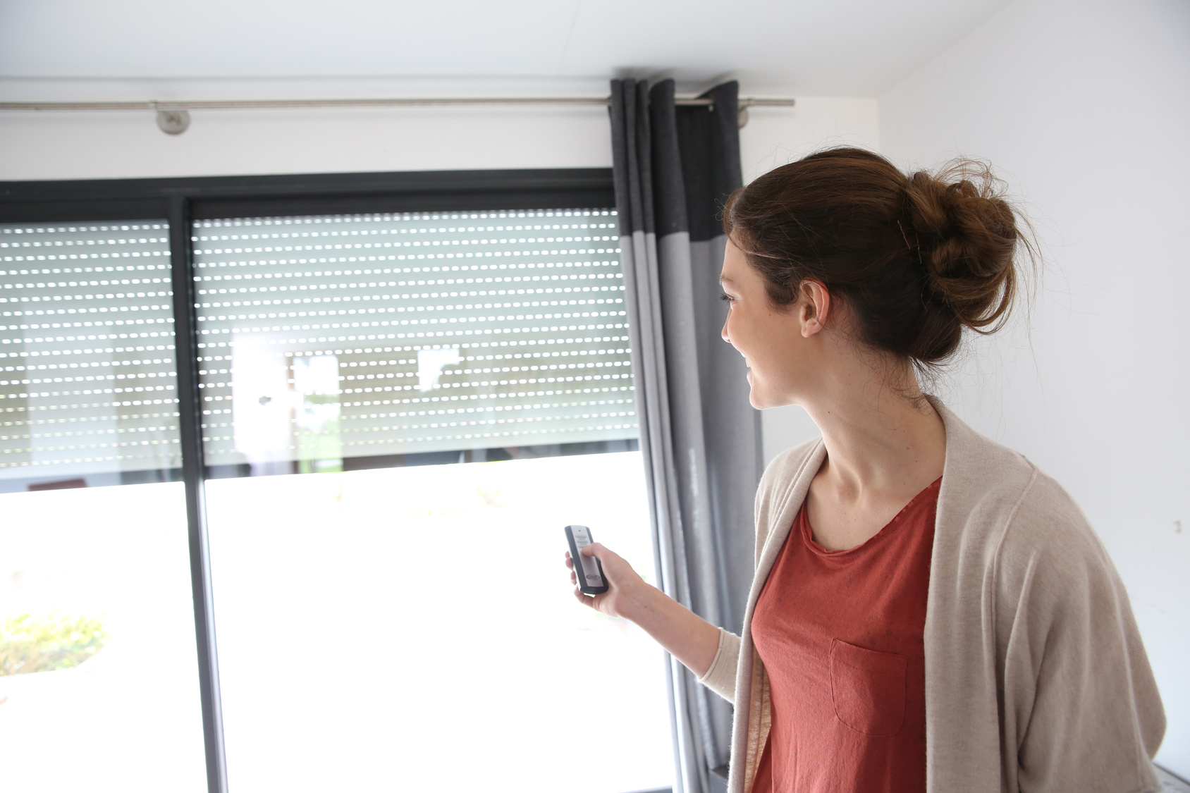 Woman using remote control to open electric shutter